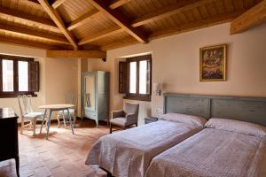 1 dormitorio con 2 camas, mesa y sillas en Los Apartamentos del Palacio en Casalarreina