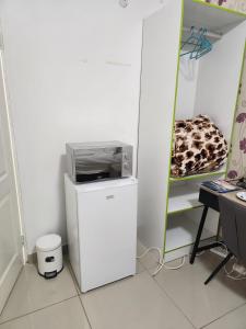 a microwave sitting on top of a refrigerator in a room at Pinto City Motel in Kempton Park