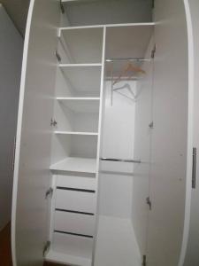 a white closet with empty shelves in a room at Hermoso dpto en condominio residencial en estreno in Paucarpata