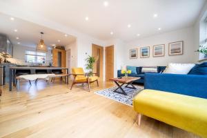 uma sala de estar com um sofá azul e uma mesa em Huckleberry - Premium, Hot Tub, x2 Parking, Farm Shop Next door, Private Cornish Lane em Newquay