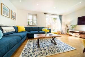 uma sala de estar com um sofá azul e uma mesa de centro em Huckleberry - Premium, Hot Tub, x2 Parking, Farm Shop Next door, Private Cornish Lane em Newquay