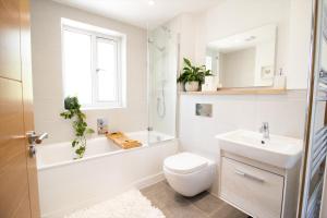 a bathroom with a sink and a toilet and a bath tub at Huckleberry - Premium, Hot Tub, x2 Parking, Farm Shop Next door, Private Cornish Lane in Newquay