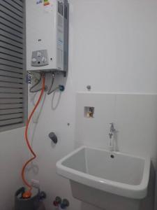a bathroom with a sink and a tv on the wall at Hermoso dpto en condominio residencial en estreno in Paucarpata