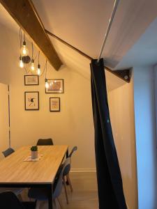 comedor con mesa de madera y sillas en Le Dortoir Daubigny, en Auvers-sur-Oise