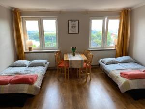 um quarto com duas camas, uma mesa e janelas em Mira - Mira pokoje z widokiem na jezioro em Chmielno