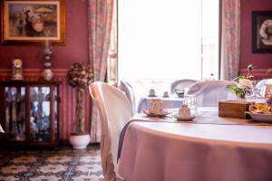 una sala da pranzo con tavolo e sedie bianche di Casa Tonina a Carloforte