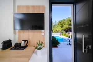 a living room with a tv and a sliding glass door at Hotel ASTERA in Skala Rachoniou