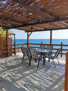 patio ze stołem i krzesłami oraz oceanem w obiekcie Συγκρότημα Διαμερισμάτων ''Όνειροι'' - Ίκελος w mieście Zagora