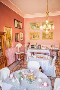 una sala da pranzo con tavoli bianchi e sedie bianche di Casa Tonina a Carloforte