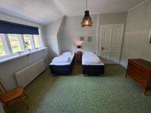 um quarto com duas camas, uma mesa e janelas em Living Ludvika em Ludvika