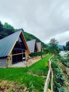 a cabin on the side of a river with grass at Seyridere bungalov in Çamlıhemşin