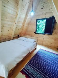 a bedroom in a log cabin with a bed and a rug at Seyridere bungalov in Çamlıhemşin
