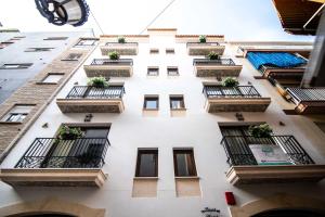 a tall white building with balconies and plants on it at Maremar Suites in Benidorm