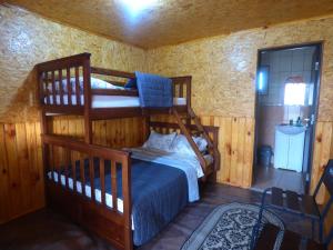 a bedroom with two bunk beds and a bathroom at Приватна Садиба "У Оксани" in Pulʼmo