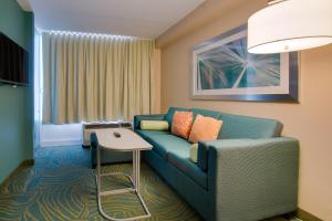 a living room with a blue couch and a table at SpringHill Suites by Marriott Orlando Lake Buena Vista South in Kissimmee