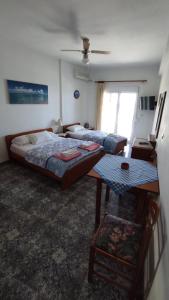 a bedroom with two beds and a table in it at Peristerianos apartments in Nea Skioni