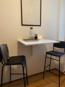 two chairs and a counter with a table and two glasses at Nette Wohnung, 8 km RB Ring in Fohnsdorf