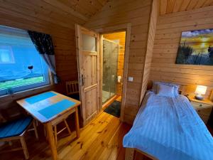 a bedroom with a bed and a desk in a cabin at WYSPA BOCIANA - Twój azyl na końcu świata in Chostka +16 photos