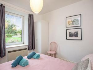 a bedroom with a pink bed and a window at Headland Cottages in Coverack