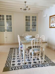 een eetkamer met een tafel en stoelen op een tapijt bij Casa de pueblo con encanto para desconectar in Terque