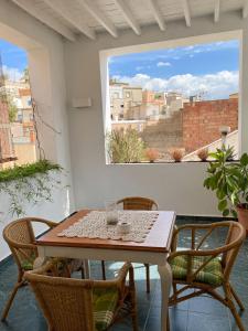 a table and chairs on a balcony with a window at Casa de pueblo con encanto para desconectar in Terque