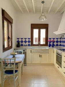 a kitchen with white cabinets and a table with chairs at Casa de pueblo con encanto para desconectar in Terque