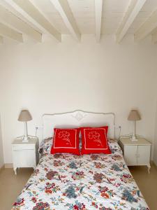 a bedroom with a bed with two red pillows at Casa de pueblo con encanto para desconectar in Terque