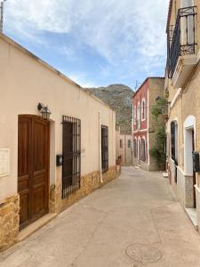 an alley with buildings and a wooden door at Casa de pueblo con encanto para desconectar in Terque