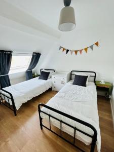 a bedroom with two beds and a window at Appartement Cottage au cœur de Nemours in Nemours