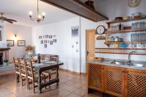 a kitchen with a table and chairs and a sink at Casa Rural Emilio con 4 dormitorios in Málaga