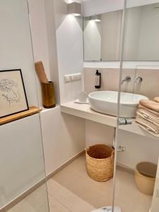 a white bathroom with a sink and a mirror at ADI BOUTIQUE HOUSE in Thessaloniki