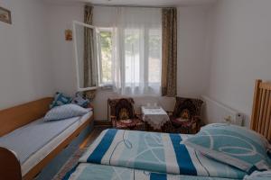 a bedroom with a bed and a couch and a window at Pensiunea La Maison Verte in Pietroasa