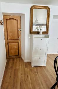 a room with a dresser and a mirror and a door at Appartement Cottage au cœur de Nemours in Nemours