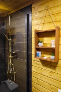 y baño con ducha y pared de madera. en Eco cottage Kazbegi, en Kazbegi