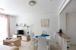カボ・ロイグにあるElsa's Rotonda Apartmentの白いリビングルーム(テーブル、椅子付)