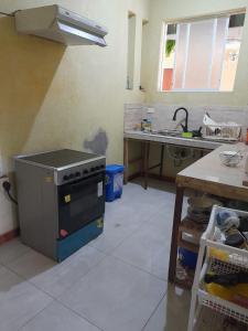 - une cuisine avec une cuisinière au milieu d'une pièce dans l'établissement Hotel las Acacias Hospedajes en Nueva Loja, à Nueva Loja