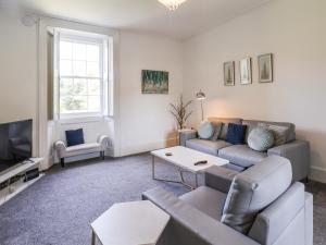 a living room with a couch and a tv at The Garden Apartment in Yarm