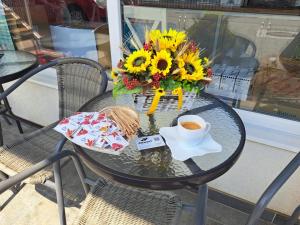 a table with a vase of sunflowers and a cup of coffee at Premont Studios Ghimbav in Ghimbav