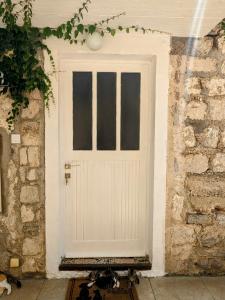 a white door on a stone wall with a window at Nadalina Guest House in Kotor