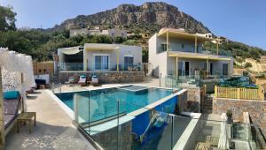 a house with a swimming pool with a mountain in the background at Zax sea view villas in Ierápetra