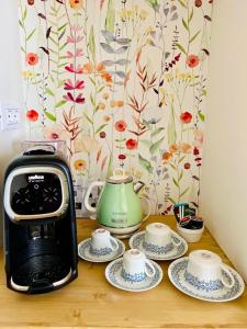 a counter with a toaster and three cups and plates at Palazzo Matà Boutique Hotel in Taranto