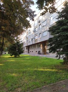 un gran edificio con un campo de césped delante de él en Apartman TEO, en Slavonski Brod