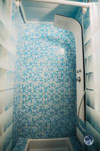 y baño con ducha de azulejos azules y lavamanos. en APPART T3, en Bagnols-sur-Cèze