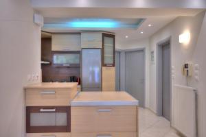 uma cozinha com armários de madeira e um frigorífico em Luxurious 2-bedroom 100m2 Apartment in Elliniko em Atenas