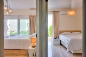 sypialnia z białym łóżkiem i oknem w obiekcie Luxurious 2-bedroom 100m2 Apartment in Elliniko w Atenach