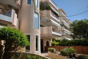 an apartment building with a balcony and a yard at Luxurious 2-bedroom 100m2 Apartment in Elliniko in Athens