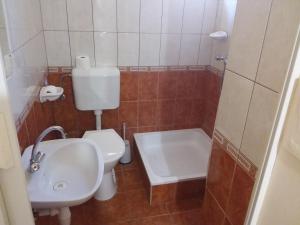 a bathroom with a toilet and a sink and a tub at Gál Apartman 2 in Hajdúszoboszló