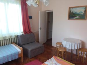 a living room with a chair and a table at Gál Apartman 2 in Hajdúszoboszló
