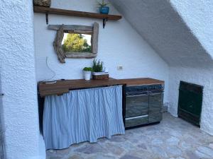 a kitchen with a counter with a stove and a window at La Collina sul Mare in Marina di Campo
