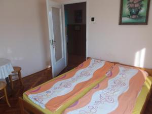 a bed with a colorful blanket on it in a room at Gál Apartman 2 in Hajdúszoboszló